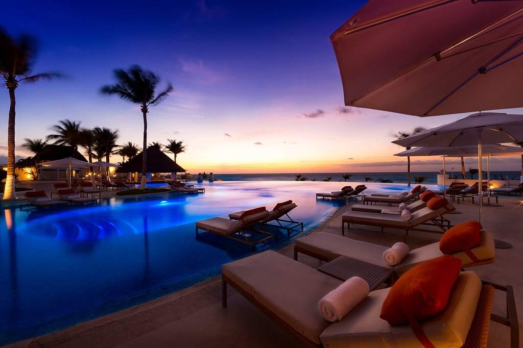 lounge chairs in front of infinity pool at dusk