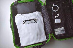 open suitcase with t-shirt and glasses