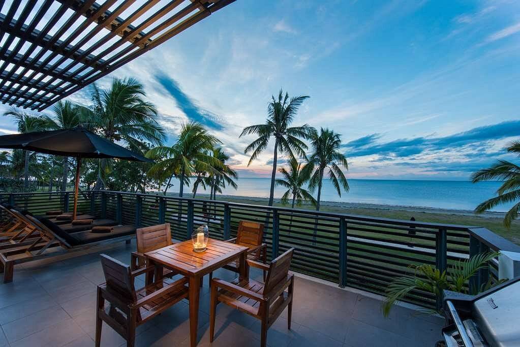 4 seat table on patio overlooking palm trees and ocean