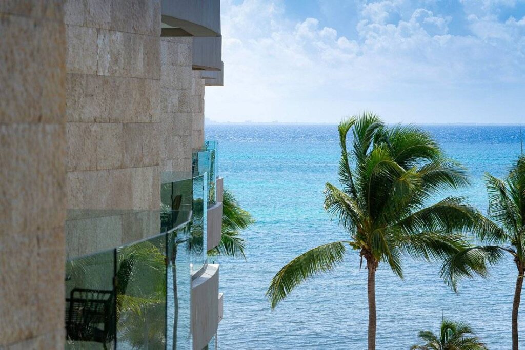 palm tree next to resort behind ocean