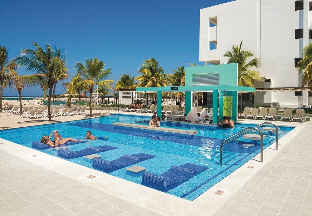 square resort pool with 4 blue cement lounge chairs