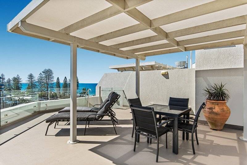 covered patio with brown lounge chairs