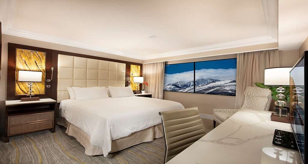 large white bed in resort room with wide windows