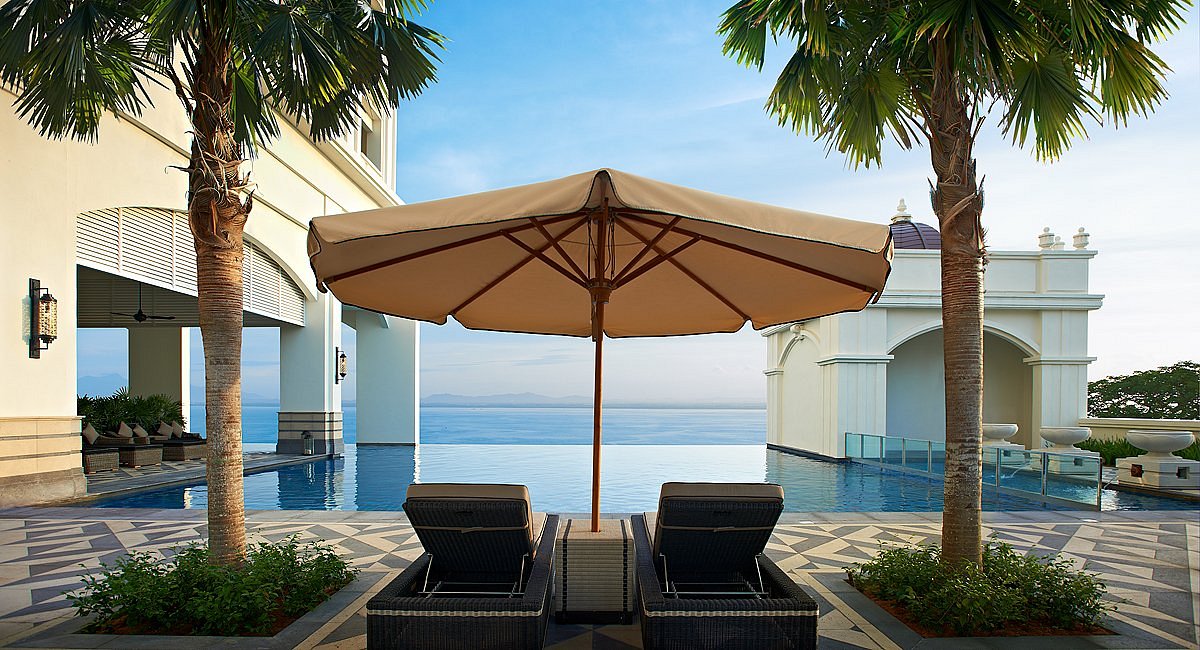 two lounge chairs under umbrella with private pool