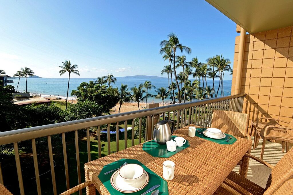 Mana Kai Maui breakfast table on balcony overlooking ocean with palm trees