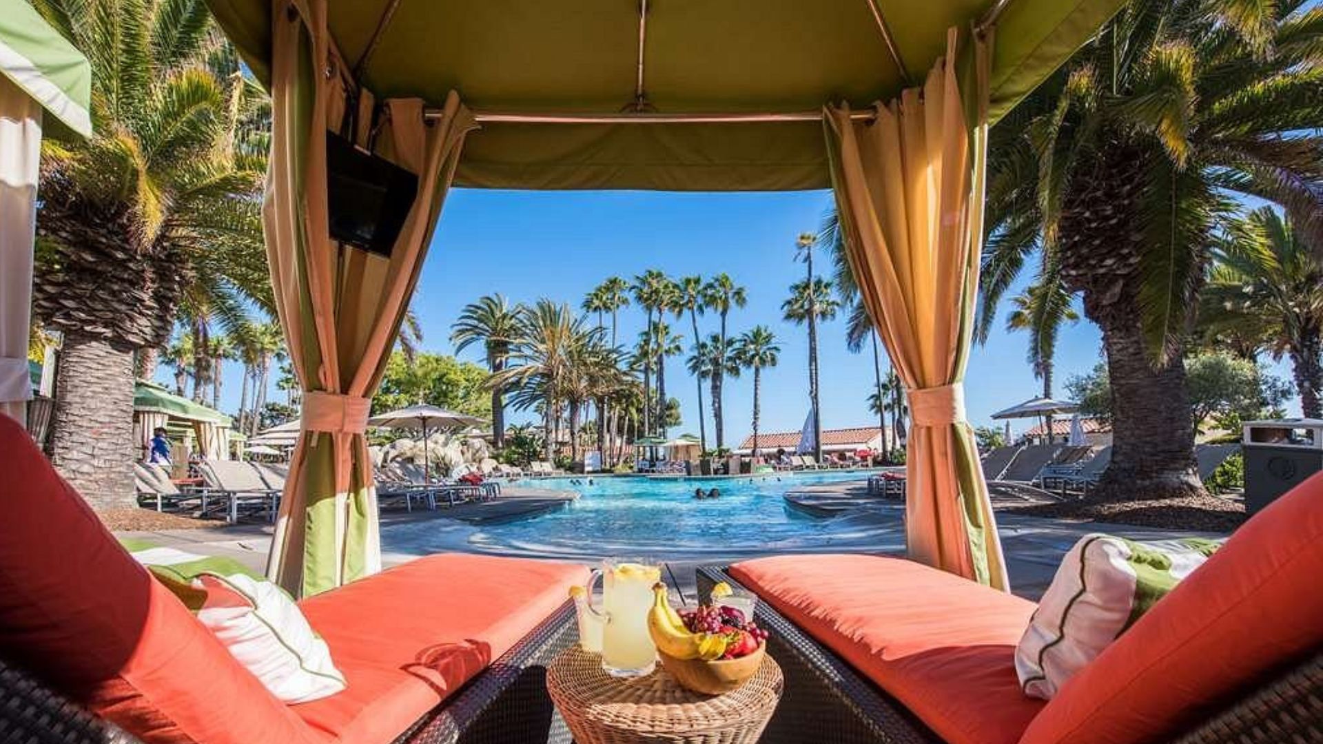 cabana with two orange lounge chairs facing pool
